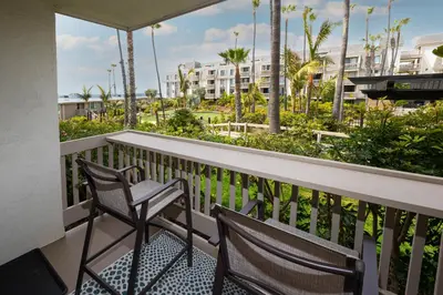 a balcony with two chairs and a view of a building at Oceanside Beach Condos in Oceanside