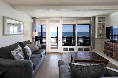 a living room with a couch and a television at Beachfront Retreat in Oceanside
