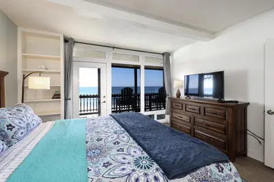 a bedroom with a bed and a flat screen tv at Beachfront Retreat in Oceanside