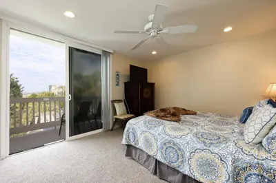 a bedroom with a bed and a sliding glass door at Oceanside Beach Condos in Oceanside