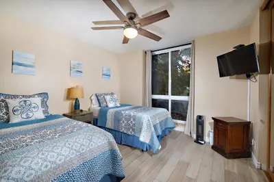 a bedroom with two beds and a flat screen tv at Oceanside Beach Condos in Oceanside
