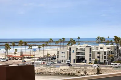 a view of a beach with palm trees and a building at Oceanside Beach Condos in Oceanside