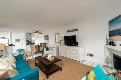a living room with a blue couch and a tv at Oceanside Beach Condos in Oceanside