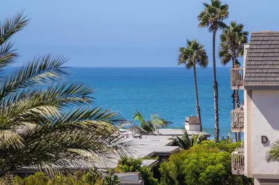 a view of a beach with palm trees and the ocean at Oceanside Beach Condos in Oceanside