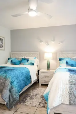 two beds in a bedroom with blue and white at Oceanside Beach Condos in Oceanside