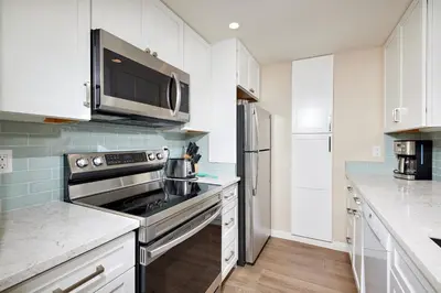 a kitchen with a stove and a microwave at Oceanside Beach Condos in Oceanside