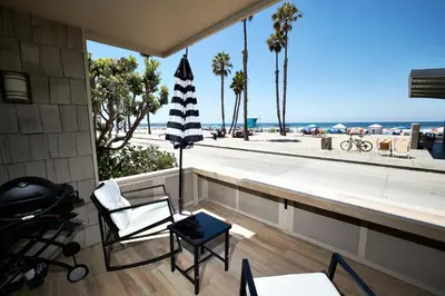 a room with a balcony with a view of the beach at Oceanside Beach Condos in Oceanside