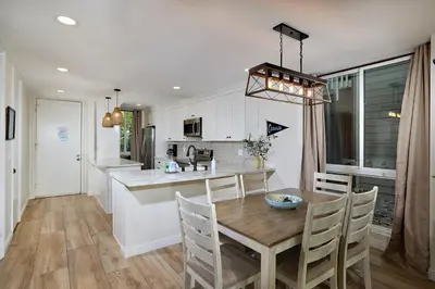 a kitchen and dining room with a wooden table and chairs at Oceanside Beach Condos in Oceanside