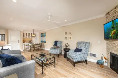 a living room with a couch and chairs and a tv at Oceanside Beach Condos in Oceanside