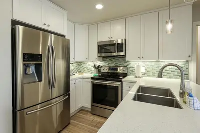 a kitchen with a stainless steel refrigerator and a sink at Oceanside Beach Condos in Oceanside