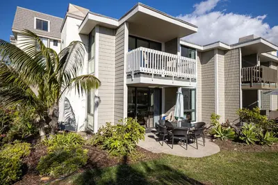 a house with a balcony and a table and chairs at Oceanside Beach Condos in Oceanside