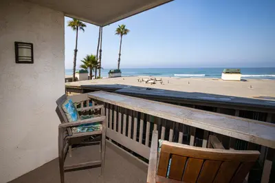 a balcony with a chair and a view of the beach at Oceanside Beach Condos in Oceanside