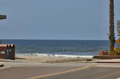 an empty street next to a beach with the ocean at Oceanside Beach Condos in Oceanside