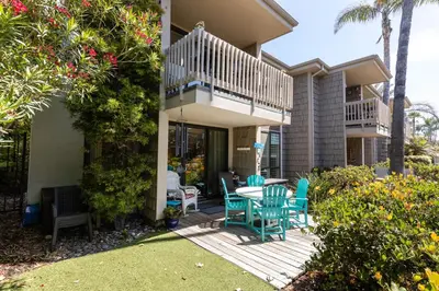 a house with a deck with a table and chairs at Oceanside Beach Condos in Oceanside