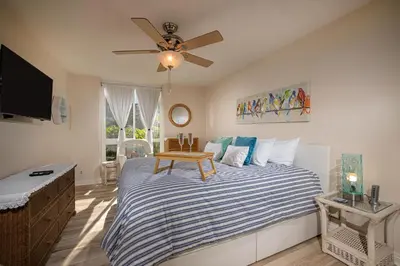 a bedroom with a bed and a ceiling fan at Oceanside Beach Condos in Oceanside