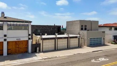a building with two garage doors on a street at Beachfront Retreat in Oceanside
