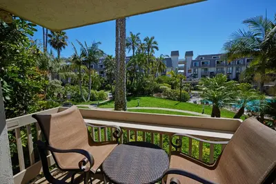 a bench on a balcony with a view of a park at Oceanside Beach Condos in Oceanside