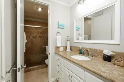 a bathroom with a sink and a toilet and a mirror at Oceanside Beach Condos in Oceanside