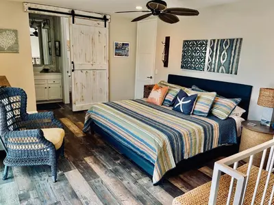 a bedroom with a bed and a chair at Oceanside Beach Condos in Oceanside