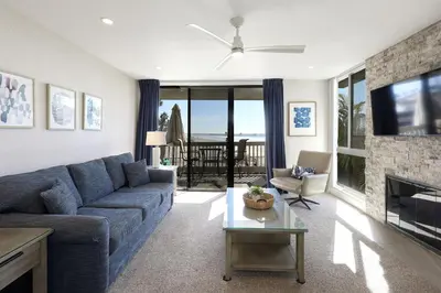 a living room with a blue couch and a fireplace at Oceanside Beach Condos in Oceanside