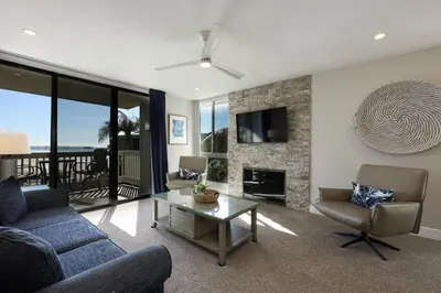 a living room with a couch and a table and a tv at Oceanside Beach Condos in Oceanside