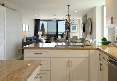 a kitchen with white cabinets and a view of the ocean at Oceanside Beach Condos in Oceanside