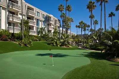 a golf course in front of a hotel with palm trees at Oceanside Beach Condos in Oceanside