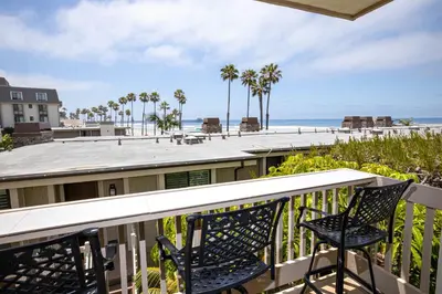 a balcony with two chairs and a view of the beach at Oceanside Beach Condos in Oceanside