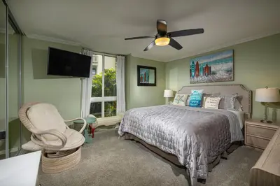 a bedroom with a bed and a ceiling fan at Oceanside Beach Condos in Oceanside