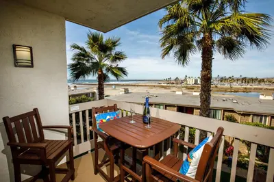 a table and chairs on a balcony with a view of the beach at Oceanside Beach Condos in Oceanside