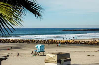 a beach with a blue lifeguard chair on the beach at Oceanside Beach Condos in Oceanside
