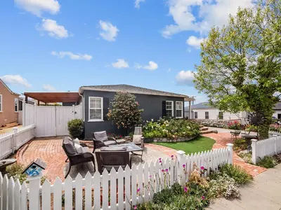a backyard with a white picket fence at Luxury beach home one block from ocean with spa, WiFi, & gorgeous outdoor space in San Diego