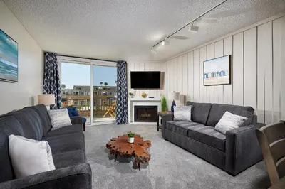 a living room with two couches and a table at Oceanside Beach Condos in Oceanside