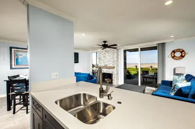 a kitchen with a sink and a living room at Oceanside Beach Condos in Oceanside