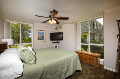 a bedroom with a bed and a ceiling fan at Oceanside Beach Condos in Oceanside
