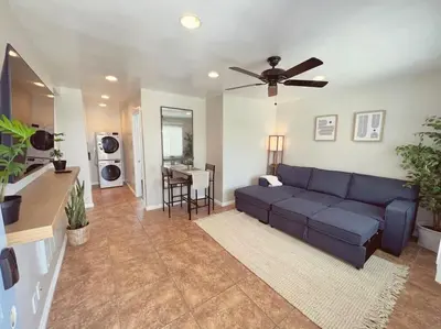 a living room with a blue couch and a ceiling fan at Beach Bungalow #3 in Newport Beach (A/C Included) in Newport Beach