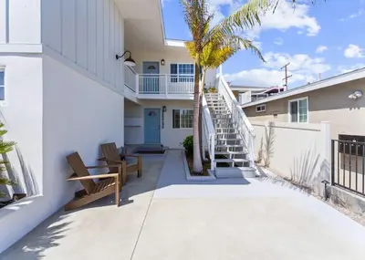 a staircase leading to a house with a palm tree at Beach Bungalow #3 in Newport Beach (A/C Included) in Newport Beach