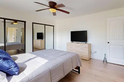 a bedroom with a bed and a ceiling fan at The Cliffside Bungalow in San Diego