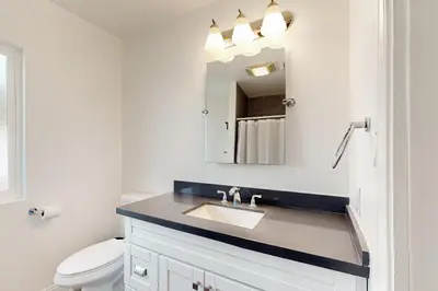 a bathroom with a sink and a mirror at The Cliffside Bungalow in San Diego