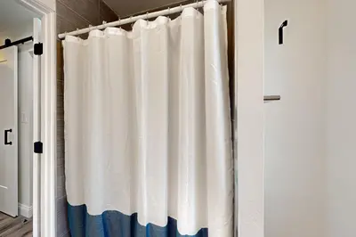 a white shower curtain in a room at The Cliffside Bungalow in San Diego