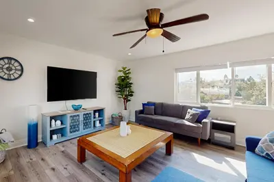 a living room with a couch and a flat screen tv at The Cliffside Bungalow in San Diego