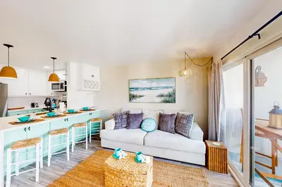 a living room with a couch and a kitchen at Pacific Street Hideaway in Oceanside