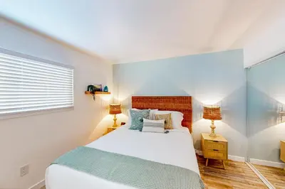 a bedroom with a large bed and two lamps at Pacific Street Hideaway in Oceanside