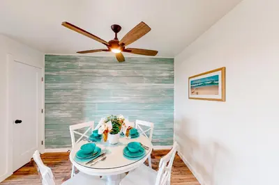a dining room with a white table and a ceiling fan at Pacific Street Hideaway in Oceanside