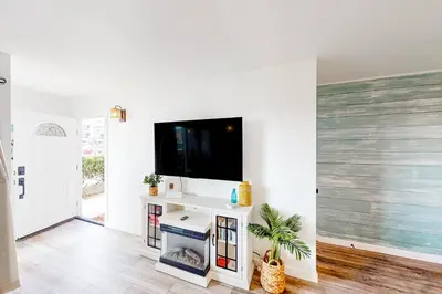 a living room with a flat screen tv on a wall at Pacific Street Hideaway in Oceanside