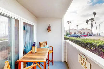 a porch with a wooden table and chairs and a window at Pacific Street Hideaway in Oceanside