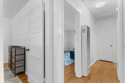 a hallway with white walls and white doors and wood floors at Cozy, home with hottub and patio in San Diego