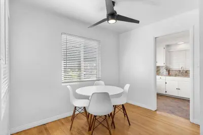 a white dining room with a table and white chairs at Cozy, home with hottub and patio in San Diego