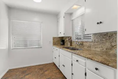 a kitchen with white cabinets and a sink at Cozy, home with hottub and patio in San Diego