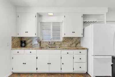a kitchen with white cabinets and a sink at Cozy, home with hottub and patio in San Diego